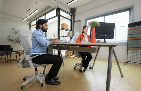 In a contemporary office, two young entrepreneurs are on a mission to generate ideas and establish a business projectの写真素材