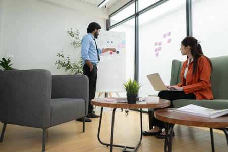 In a contemporary office, two young entrepreneurs are on a mission to generate ideas and establish a...