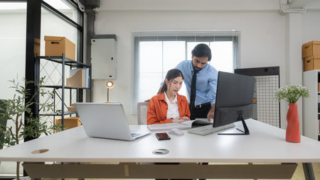 In a contemporary office, two young entrepreneurs are on a mission to generate ideas and establish a business projectの写真素材