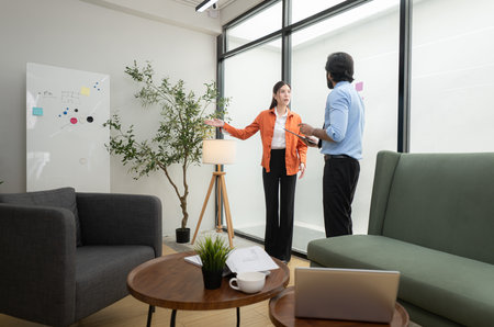 In a contemporary office, two young entrepreneurs are on a mission to generate ideas and establish a business projectの写真素材