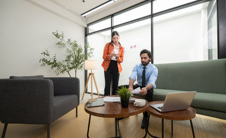 In a contemporary office, two young entrepreneurs are on a mission to generate ideas and establish a business projectの写真素材
