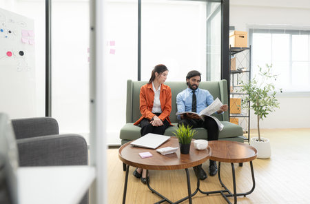 In a contemporary office, two young entrepreneurs are on a mission to generate ideas and establish a business projectの写真素材