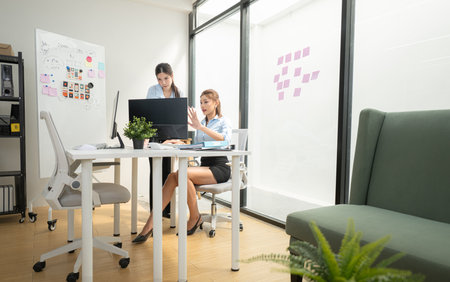 In a contemporary office, two young woman entrepreneurs are on a mission to generate ideas and establish a business projectの写真素材
