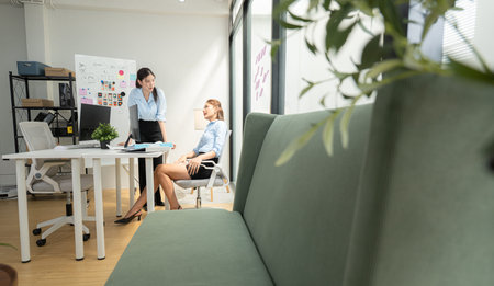In a contemporary office, two young woman entrepreneurs are on a mission to generate ideas and establish a business projectの写真素材