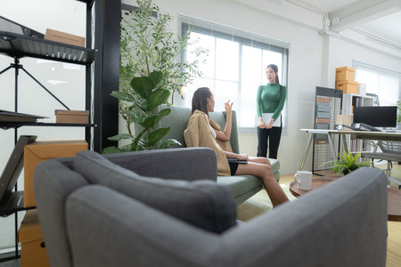 In a contemporary office, two young woman entrepreneurs are on a mission to generate ideas and establish a business projectの写真素材