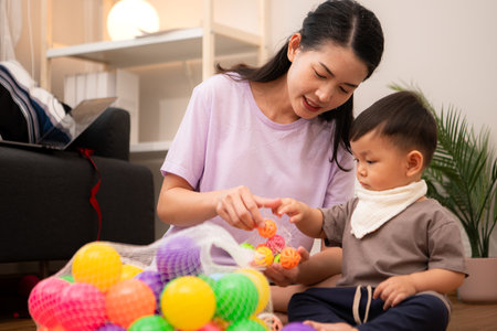 While in vacation at home, a mother engages in activities with little kidの写真素材