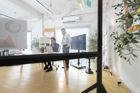 In a contemporary office, two senior executives with a mission to brainstorm and monitor the progress of a business projectの写真素材
