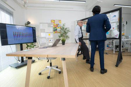 In a contemporary office, two senior executives with a mission to brainstorm and monitor the progress of a business projectの写真素材