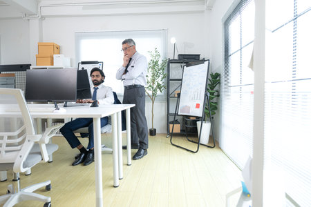In a contemporary office, two senior executives with a mission to brainstorm and monitor the progress of a business projectの写真素材