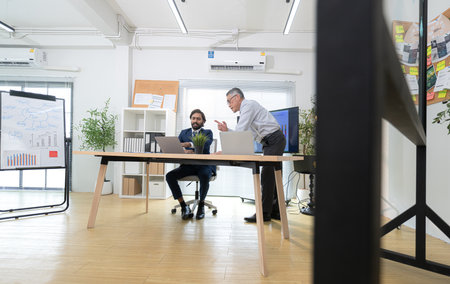 In a contemporary office, two senior executives with a mission to brainstorm and monitor the progress of a business projectの写真素材