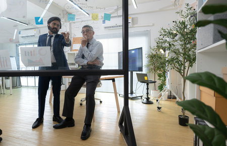 In a contemporary office, two senior executives with a mission to brainstorm and monitor the progress of a business projectの写真素材