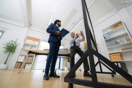In a contemporary office, two senior executives with a mission to brainstorm and monitor the progress of a business projectの写真素材