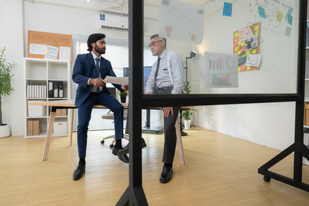 In a contemporary office, two senior executives with a mission to brainstorm and monitor the...
