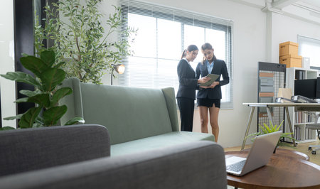 In a contemporary office, two young woman entrepreneurs are on a mission to generate ideas and establish a business projectの写真素材