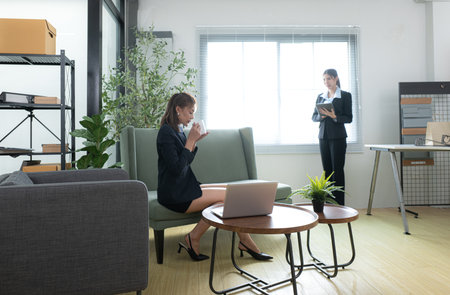 In a contemporary office, two young woman entrepreneurs are on a mission to generate ideas and establish a business projectの写真素材