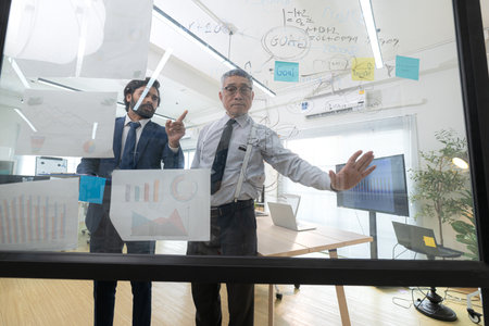 In a contemporary office, two senior executives with a mission to brainstorm and monitor the progress of a business projectの写真素材