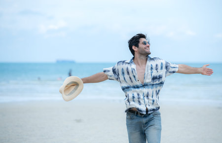 Young man on vacation on a white sandy beach, clear sky and seaの写真素材