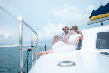 A young couple are enjoying seaside adventure aboard a yachtの写真素材