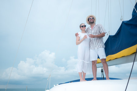 A young couple are enjoying seaside adventure aboard a yachtの写真素材
