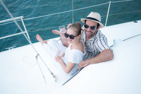 A young couple are enjoying seaside adventure aboard a yachtの写真素材
