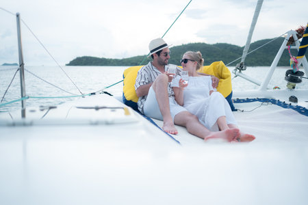 A young couple are enjoying seaside adventure aboard a yachtの写真素材
