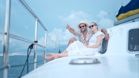 A young couple are enjoying seaside adventure aboard a yachtの写真素材