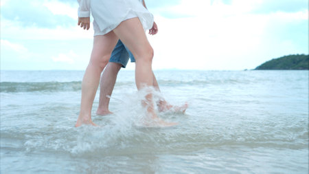 Young couple on vacation on a white sandy beach, clear sky and seaの写真素材