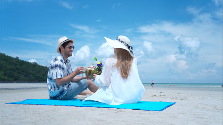 Young couple on vacation on a white sandy beach, clear sky and seaの写真素材