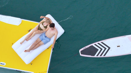 A young couple are enjoying seaside adventure aboard a yachtの写真素材