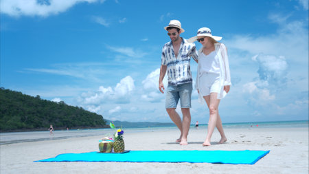 Young couple on vacation on a white sandy beach, clear sky and seaの写真素材