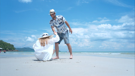 Young couple on vacation on a white sandy beach, clear sky and seaの写真素材