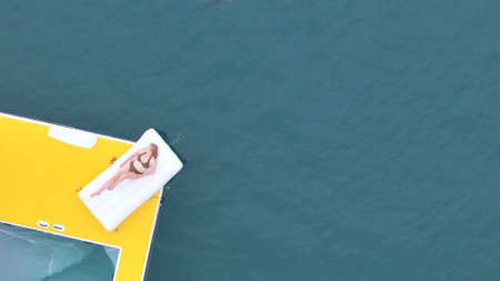 A young woman are enjoying seaside adventure aboard a yachtの写真素材
