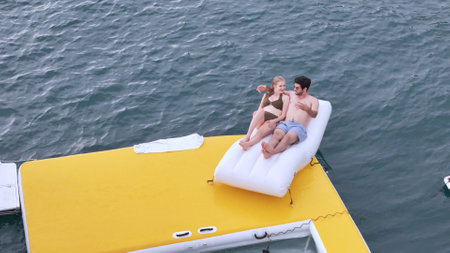A young couple are enjoying seaside adventure aboard a yachtの写真素材