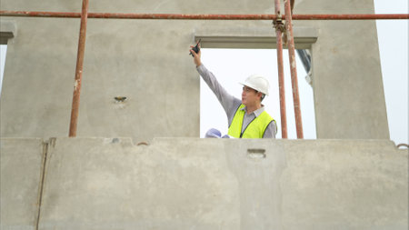 Engineers construction projects inspect and supervise the construction of building walls and foundations of residential buildingsの写真素材