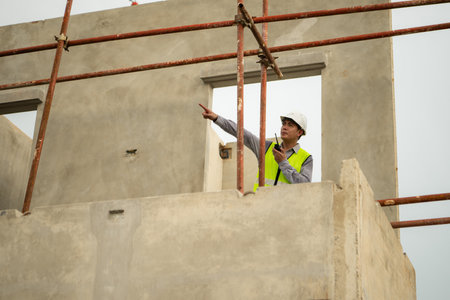 Engineers construction projects inspect and supervise the construction of building walls and foundations of residential buildingsの写真素材