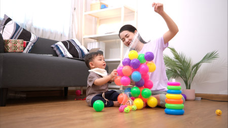 While in vacation at home, a mother engages in activities with little kidの写真素材