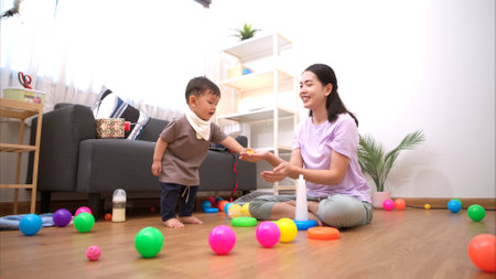 While in vacation at home, a mother engages in activities with little kidの写真素材