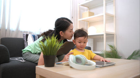 While in vacation at home, a mother engages in activities with little kidの写真素材