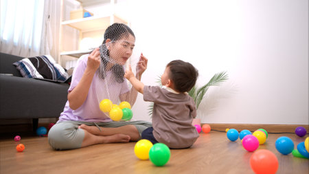 While in vacation at home, a mother engages in activities with little kidの写真素材