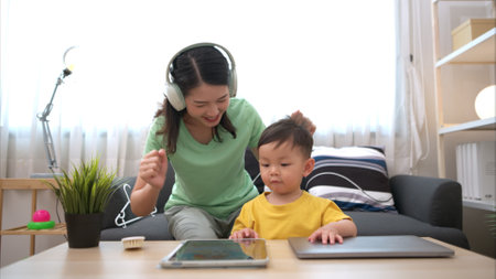 While in vacation at home, a mother engages in activities with little kidの写真素材