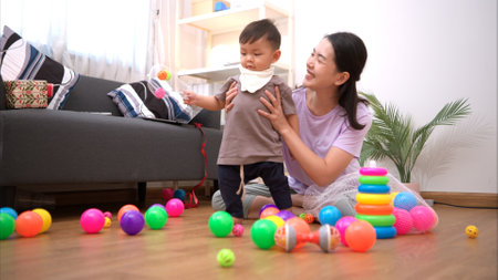 While in vacation at home, a mother engages in activities with little kidの写真素材