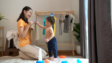 Mom and little child dressing at home in the morningの写真素材