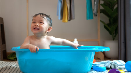 Mom and little child with taking a shower and dressing at home in the morningの写真素材