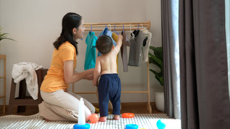 Mom and little child with dressing at home in the morningの写真素材