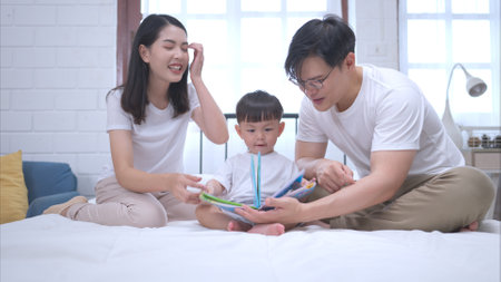 Before putting the kids to bed, parents, and kid unwind and play in the bedroomの写真素材