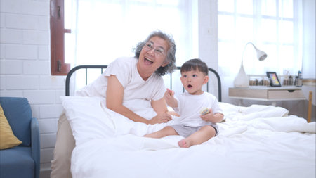 Before putting the kids to bed, grandparents, and kid unwind and play in the bedroomの写真素材