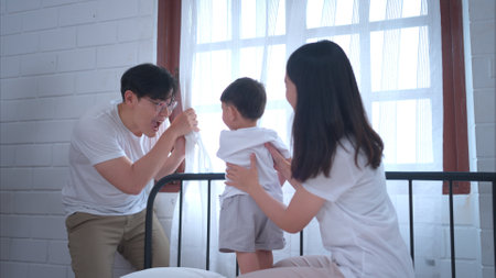 Before putting the kids to bed, parents, and kid unwind and play in the bedroomの写真素材
