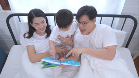 Before putting the kids to bed, parents, and kid unwind and play in the bedroomの写真素材