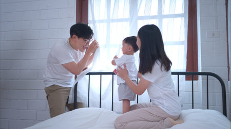 Before putting the kids to bed, parents, and kid unwind and play in the bedroomの写真素材