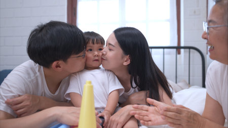 Before putting the kids to bed, parents, grandparents, and kid unwind and play in the bedroomの写真素材